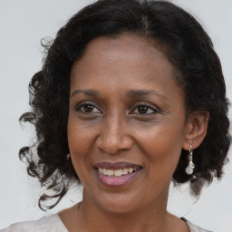 Joyful black adult female with medium  brown hair and brown eyes