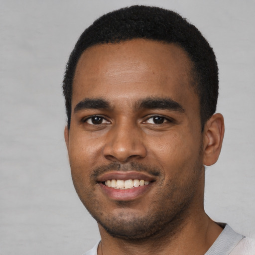 Joyful black young-adult male with short  black hair and brown eyes