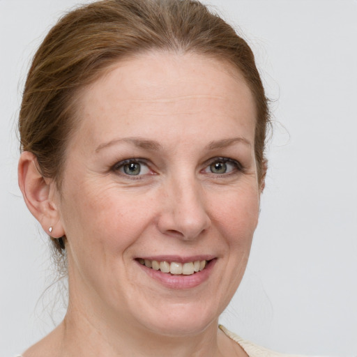 Joyful white adult female with medium  brown hair and blue eyes