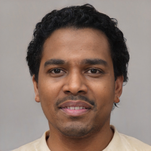 Joyful black young-adult male with short  black hair and brown eyes