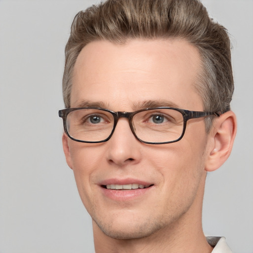 Joyful white adult male with short  brown hair and blue eyes