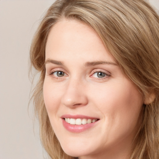 Joyful white young-adult female with long  brown hair and blue eyes