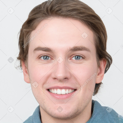 Joyful white young-adult male with short  brown hair and blue eyes