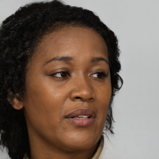 Joyful black adult female with long  brown hair and brown eyes
