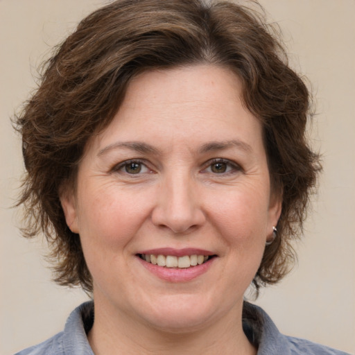 Joyful white adult female with medium  brown hair and grey eyes