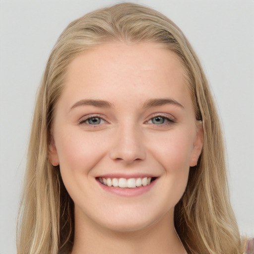 Joyful white young-adult female with long  brown hair and blue eyes