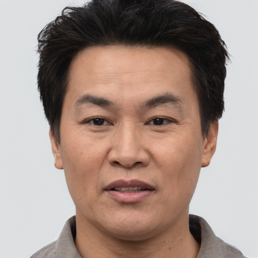 Joyful asian adult male with short  black hair and brown eyes