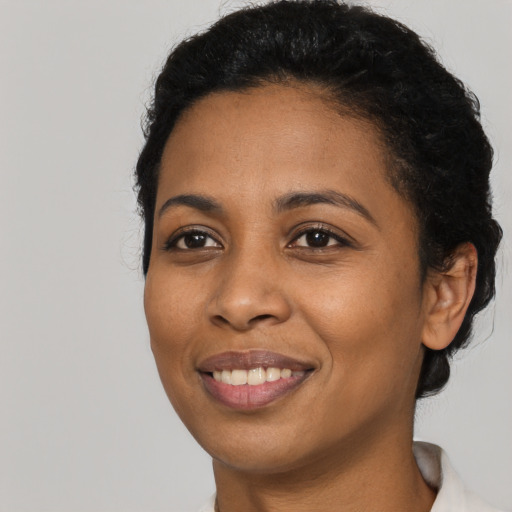 Joyful latino young-adult female with short  black hair and brown eyes