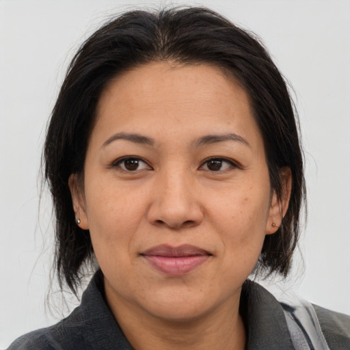 Joyful asian adult female with medium  brown hair and brown eyes