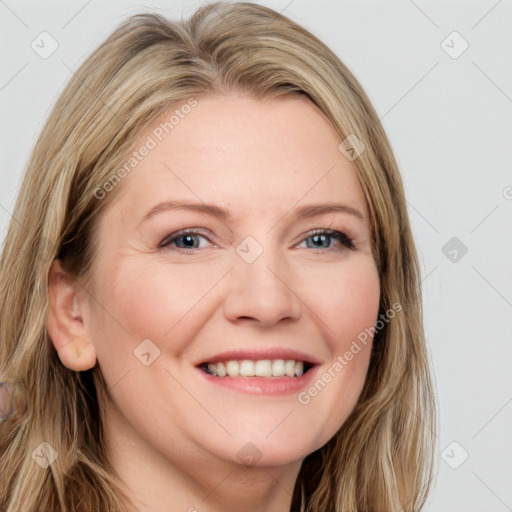 Joyful white adult female with long  brown hair and blue eyes