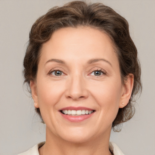 Joyful white adult female with medium  brown hair and brown eyes