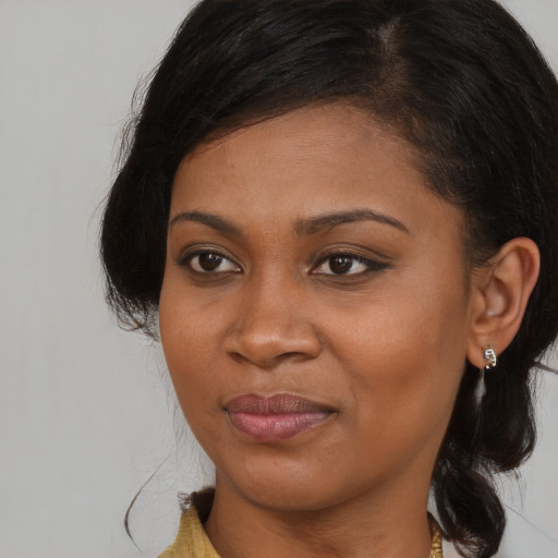 Joyful black young-adult female with long  brown hair and brown eyes