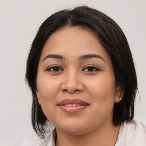 Joyful latino young-adult female with medium  brown hair and brown eyes