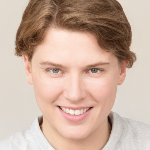 Joyful white young-adult female with short  brown hair and blue eyes