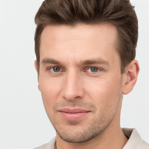 Joyful white young-adult male with short  brown hair and grey eyes