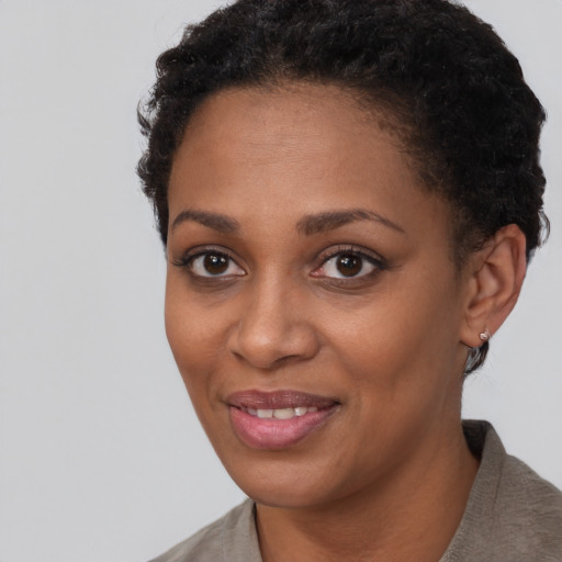 Joyful black young-adult female with short  black hair and brown eyes