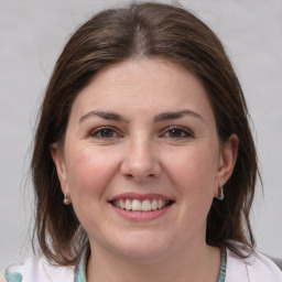 Joyful white young-adult female with medium  brown hair and grey eyes