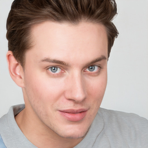 Joyful white young-adult male with short  brown hair and blue eyes