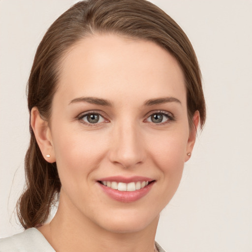 Joyful white young-adult female with medium  brown hair and grey eyes