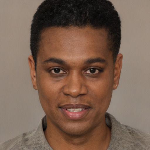 Joyful black young-adult male with short  black hair and brown eyes