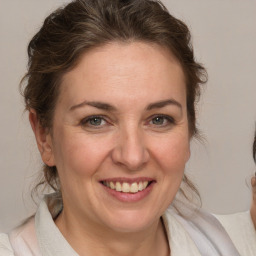 Joyful white adult female with medium  brown hair and grey eyes