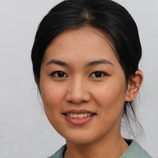Joyful asian young-adult female with medium  black hair and brown eyes