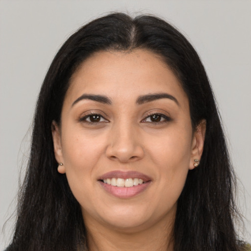 Joyful latino young-adult female with long  brown hair and brown eyes