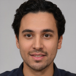 Joyful white young-adult male with short  black hair and brown eyes
