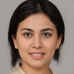 Joyful latino young-adult female with medium  brown hair and brown eyes