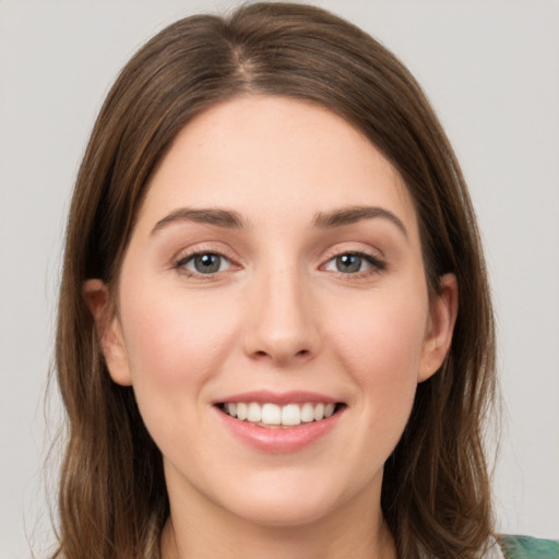 Joyful white young-adult female with long  brown hair and green eyes