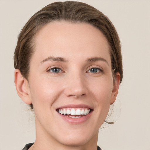 Joyful white young-adult female with medium  brown hair and grey eyes