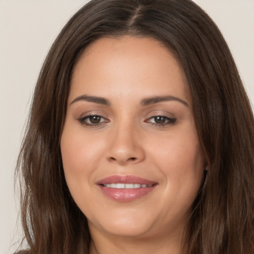 Joyful white young-adult female with long  brown hair and brown eyes