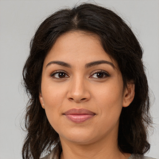 Joyful latino young-adult female with long  brown hair and brown eyes