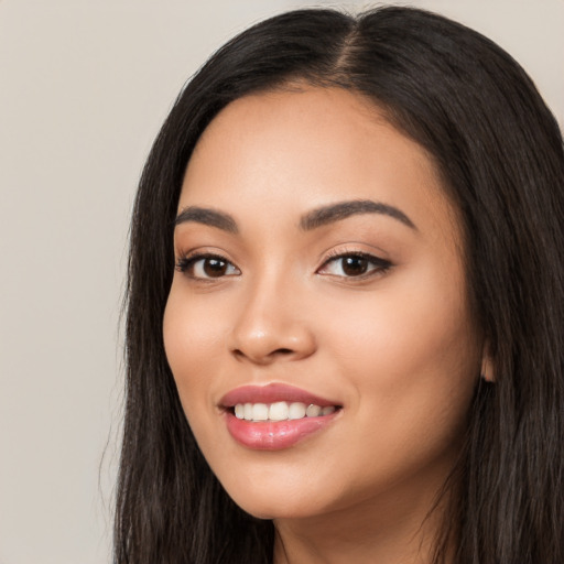 Joyful white young-adult female with long  black hair and brown eyes