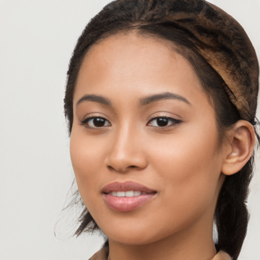 Joyful latino young-adult female with long  brown hair and brown eyes