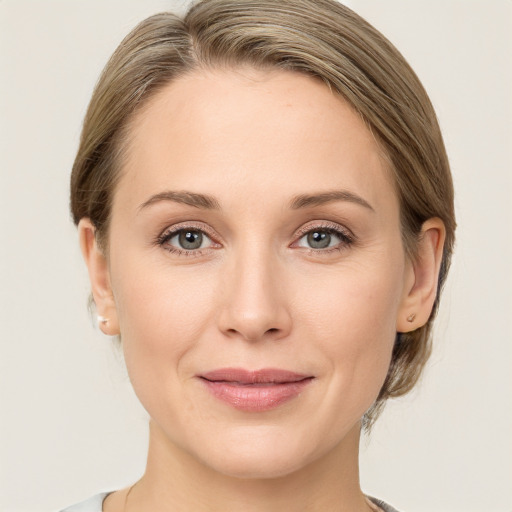 Joyful white young-adult female with medium  brown hair and grey eyes