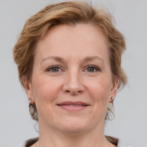 Joyful white adult female with medium  brown hair and grey eyes