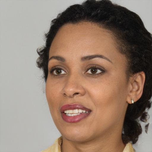 Joyful black young-adult female with medium  brown hair and brown eyes