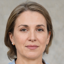 Joyful white adult female with medium  brown hair and grey eyes