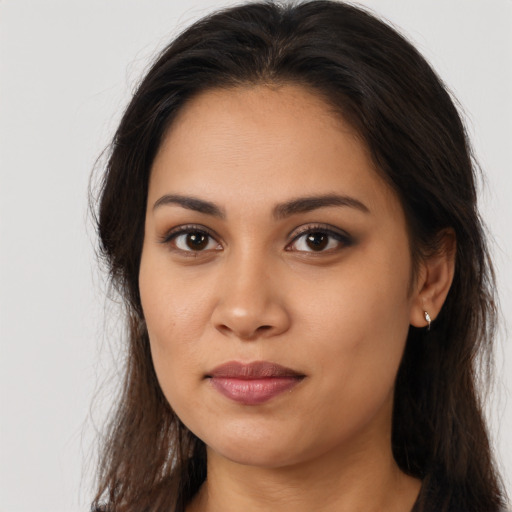 Joyful latino young-adult female with long  brown hair and brown eyes