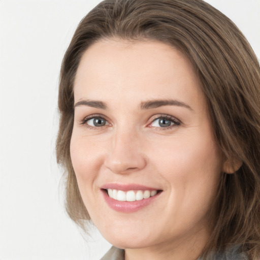 Joyful white young-adult female with medium  brown hair and grey eyes