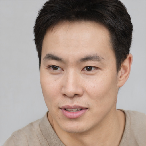 Joyful asian young-adult male with short  brown hair and brown eyes