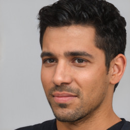 Joyful white young-adult male with short  black hair and brown eyes