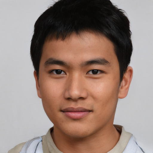 Joyful asian young-adult male with short  black hair and brown eyes