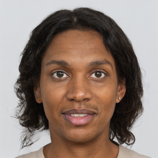 Joyful black adult female with medium  brown hair and brown eyes