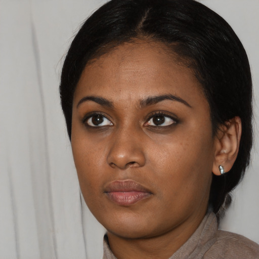 Joyful black young-adult female with medium  black hair and brown eyes