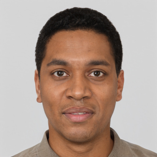 Joyful black young-adult male with short  black hair and brown eyes