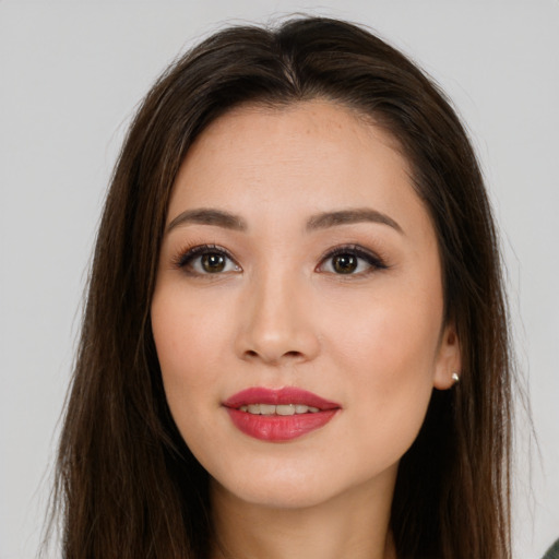 Joyful asian young-adult female with long  brown hair and brown eyes