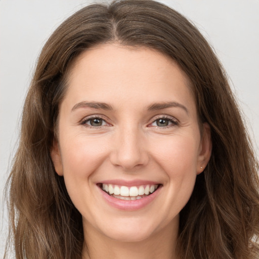 Joyful white young-adult female with long  brown hair and brown eyes