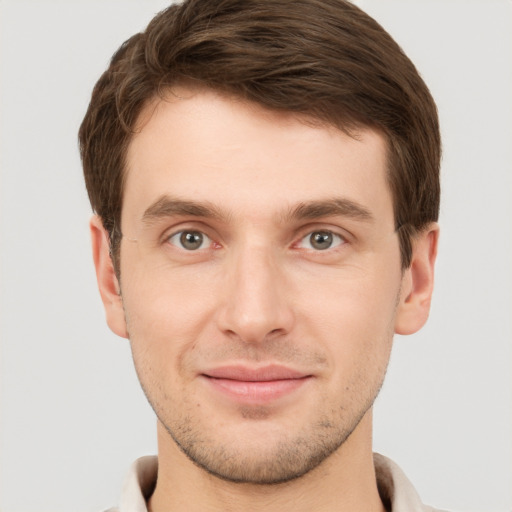 Joyful white young-adult male with short  brown hair and grey eyes